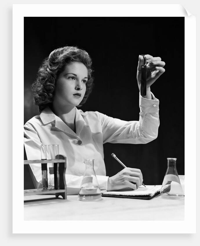 1940s Student Nurse Holding Up Test Tube While Taking Notes In Science Class by Anonymous