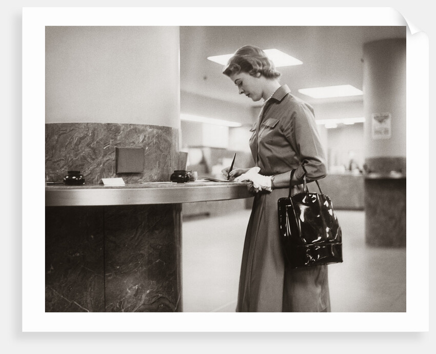 1950s 1960s Woman Handbag On Arm Gloves Filling Out Deposit Slip Bank Counter by Anonymous