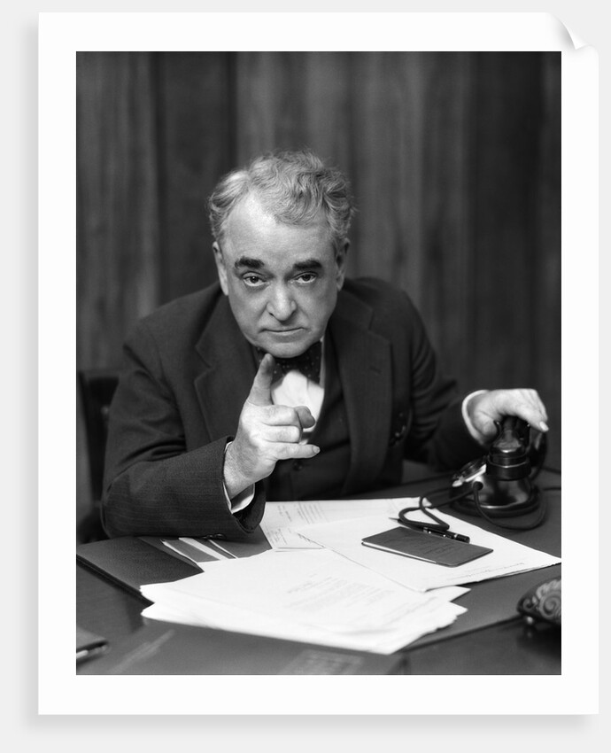 1930s Head-On Serious Senior Businessman Behind Desk Hand On Telephone Pointing by Anonymous