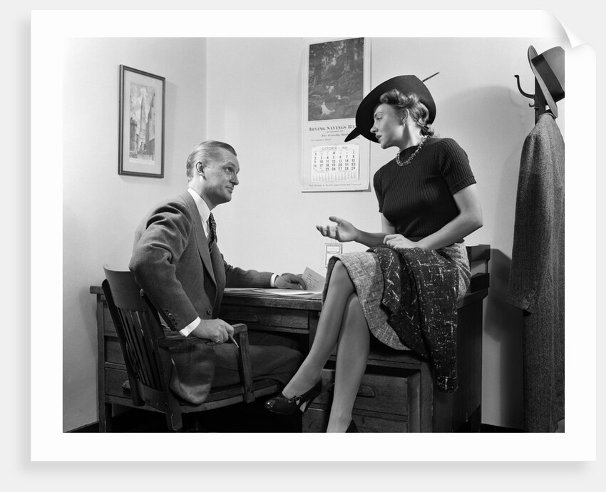 1940s Woman Sitting On Desk Hat Skirt Hand Gesture Talking Flirting With Man by Anonymous