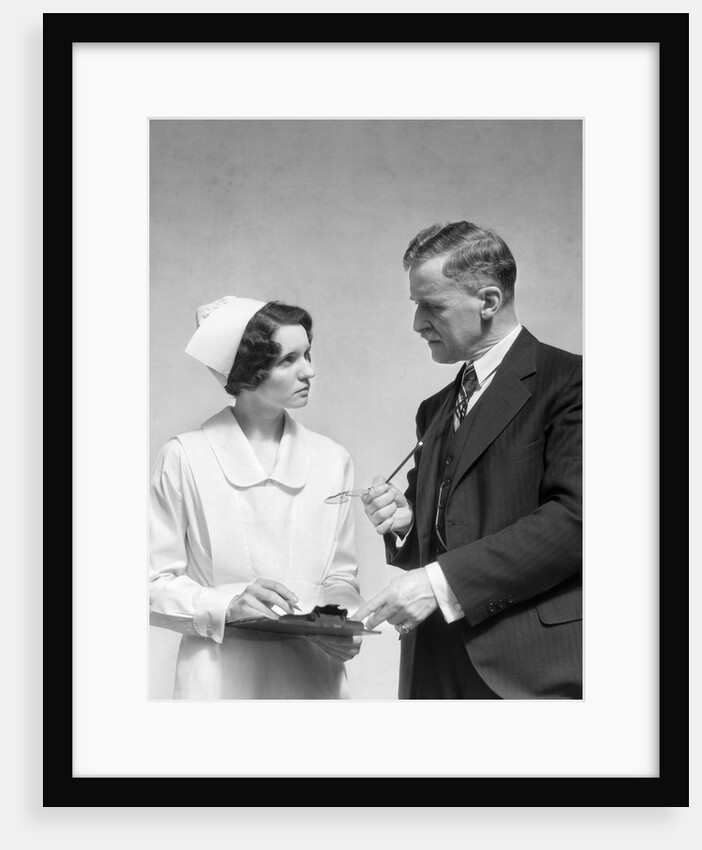 1930s Doctor In Suit And Necktie Confers With Nurse In Uniform And Cap Holding Clipboard Chart by Anonymous