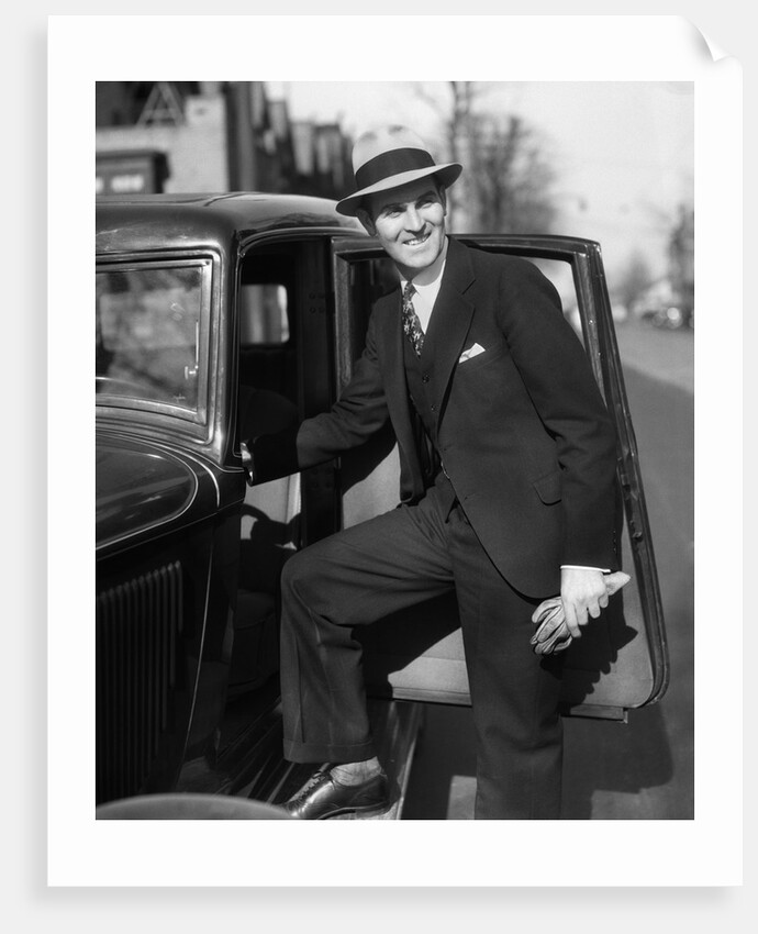 1930s Man In Suit And Hat Holding Gloves Stepping Into Automobile Driver Seat by Anonymous