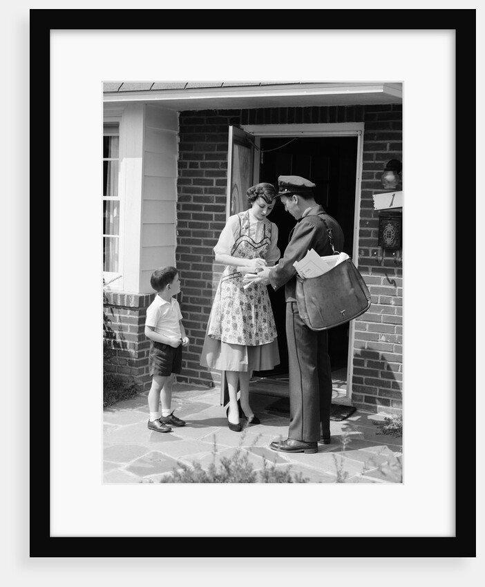 1950s Suburban Mom At Home Front Door With Son Watching Receiving Package From Mailman by Anonymous