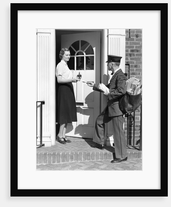 1930s Postman Giving A Letter To A Woman In The Doorway Of A Colonial Brick Home by Anonymous