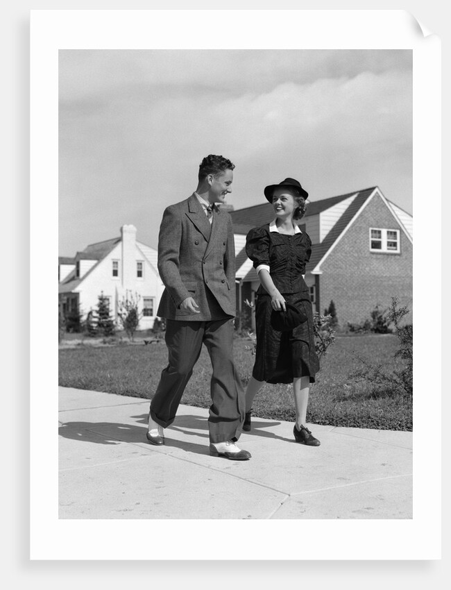 1940s Teenage Couple Walking On Suburban Sidewalk by Anonymous