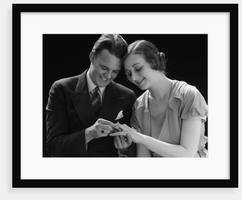 1930s Couple Sitting Heads Pressed Together Man Putting Engagement Ring On Woman's Finger by Anonymous
