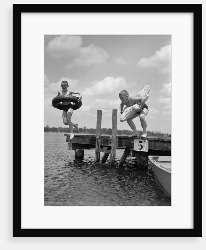 1940s 1950s Two Boys Wearing Inflatable Inner Tubes About To Jump In Lake Off Pier by Anonymous
