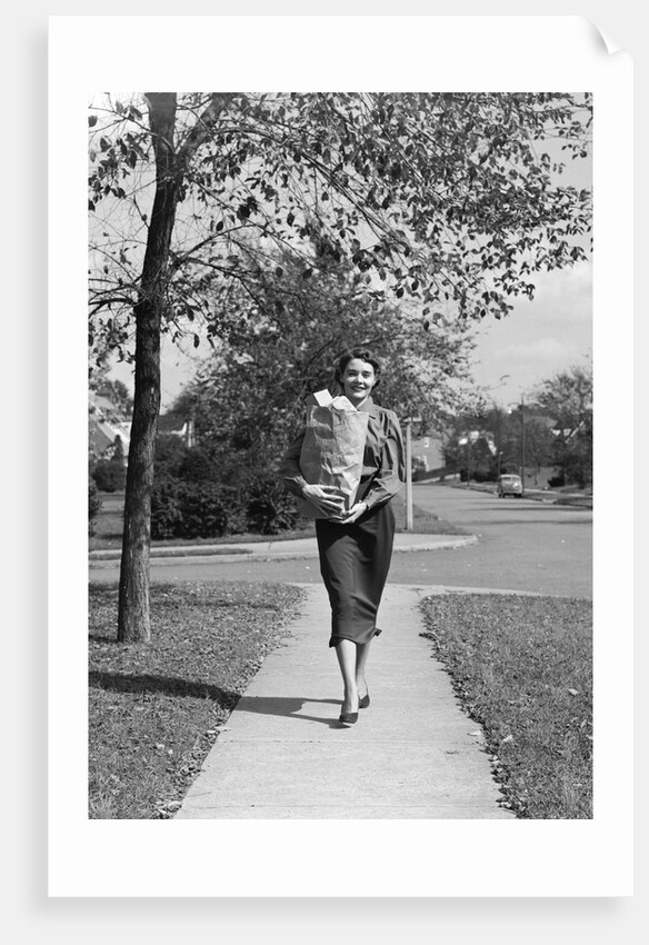 1950s Woman Walking On Sidewalk Carrying A Grocery Bag Full Of Food by Anonymous
