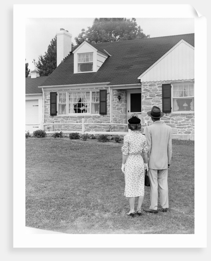 1940s 1950s Couple Standing Outside Looking At Stone Suburban House by Anonymous