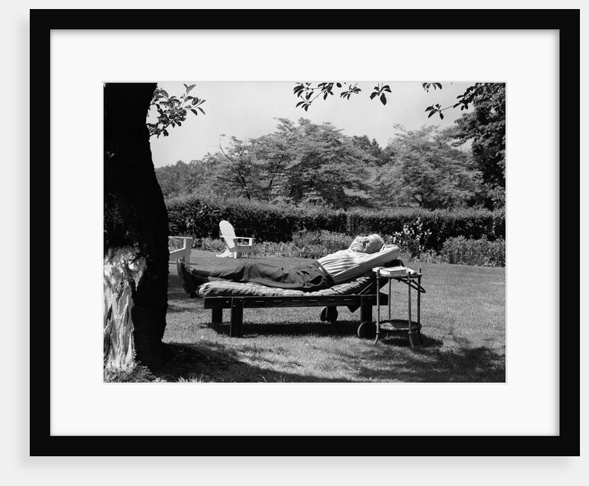 1950s Elderly Man In Backyard Stretched Out On Lounge Chair Under Tree by Anonymous