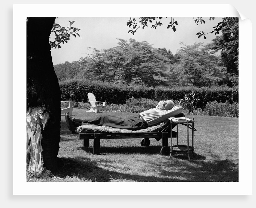 1950s Elderly Man In Backyard Stretched Out On Lounge Chair Under Tree by Anonymous