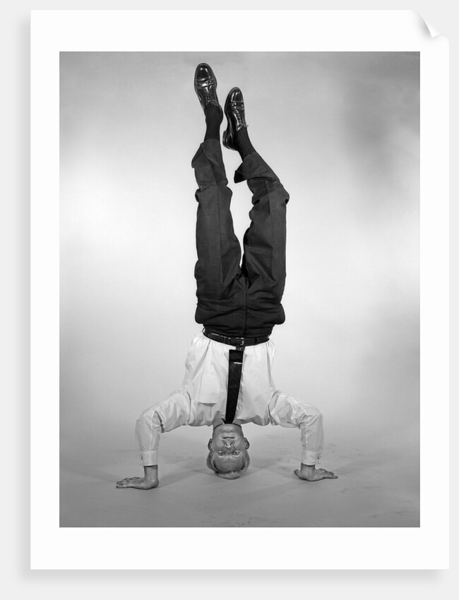 1960s Man In Shirt and Tie Standing On Head by Anonymous