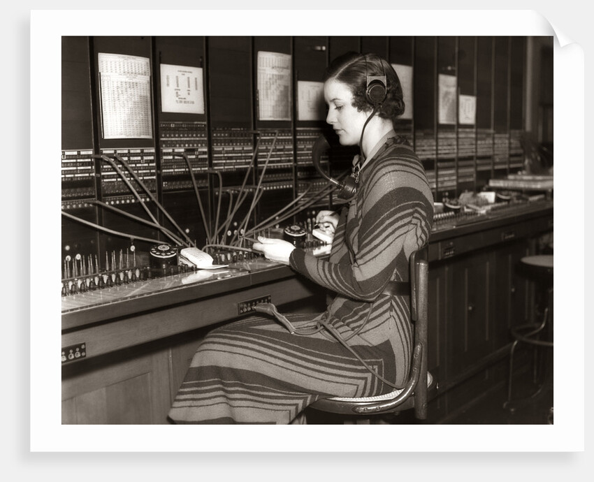 1930s Woman Telephone Operator Sitting At Large Manual Switchboard Directing Calls by Anonymous