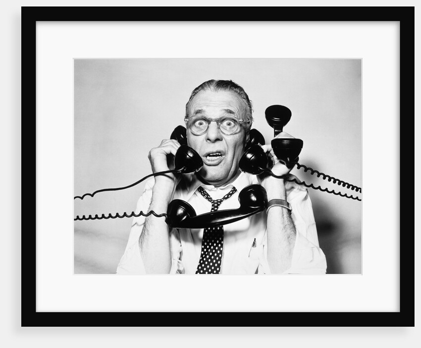 1950s 1960s Portrait Of Frazzled Businessman Trying To Answer Four Black Telephones Phones At Once by Anonymous