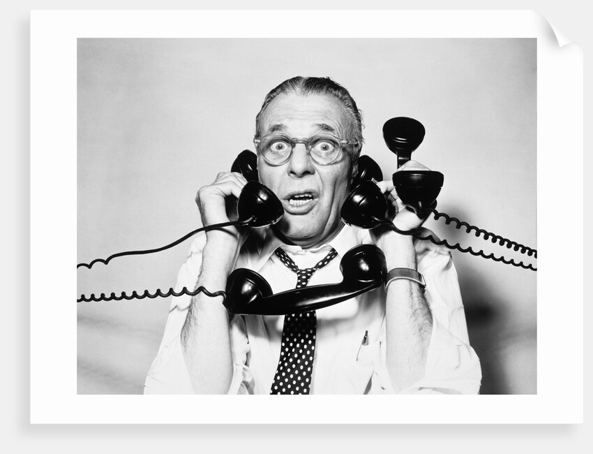 1950s 1960s Portrait Of Frazzled Businessman Trying To Answer Four Black Telephones Phones At Once by Anonymous