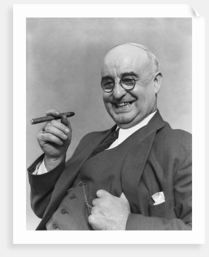 1930s Elderly Businessman In 3-Piece Suit and Glasses Leaning Back With Cigar In Hand by Anonymous