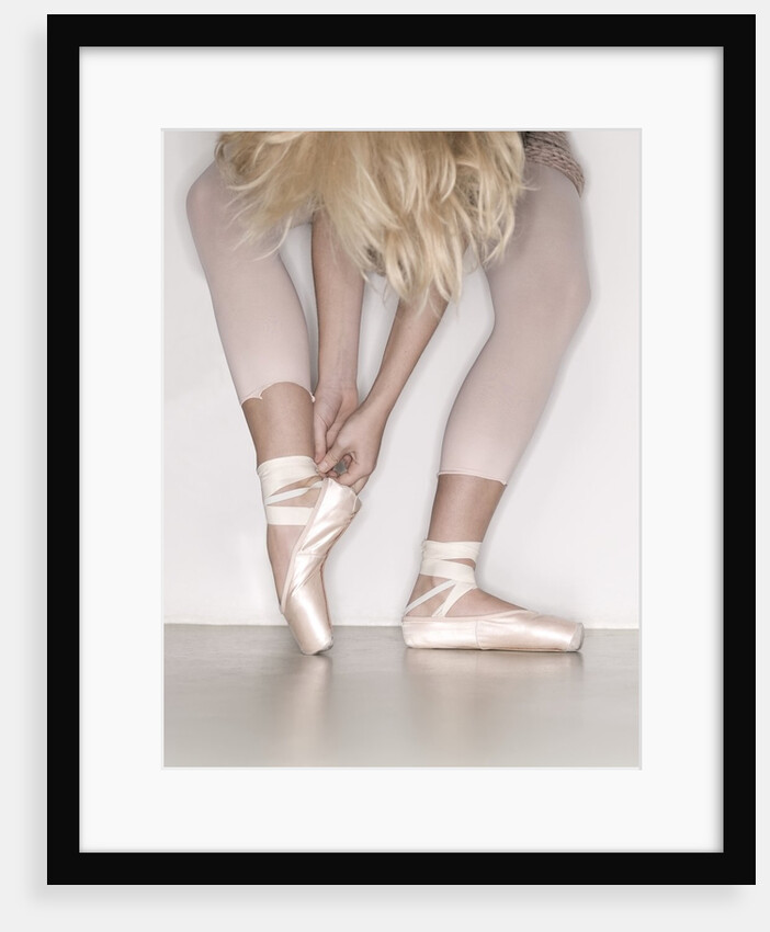 Ballerina adjusting toe shoe by Anonymous