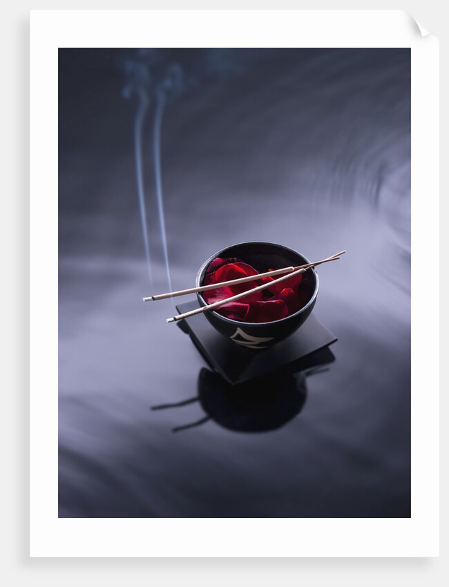 Burning incense on top of bowl of petals by Anonymous