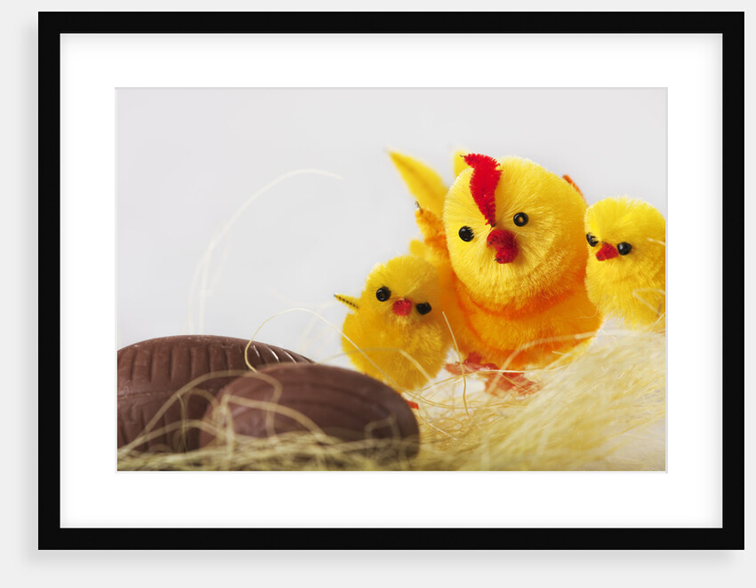 Toy chickens looking at chocolate eggs by Anonymous