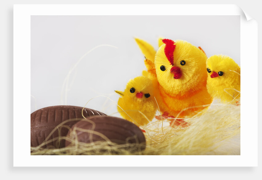 Toy chickens looking at chocolate eggs by Anonymous