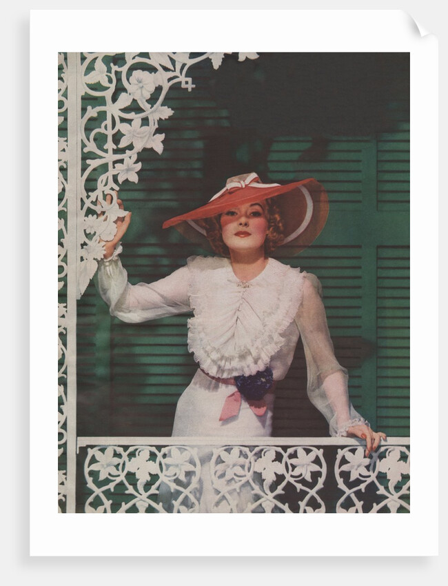 Woman with picture hat on front porch by Anonymous
