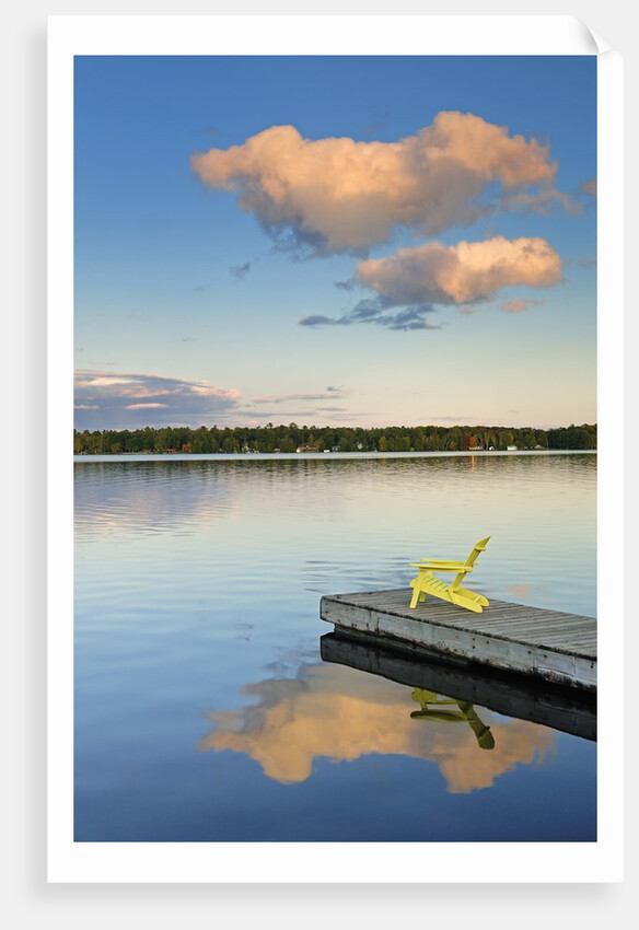 Clouds reflected in Silent Lake with Muskoka chair on dock by Anonymous