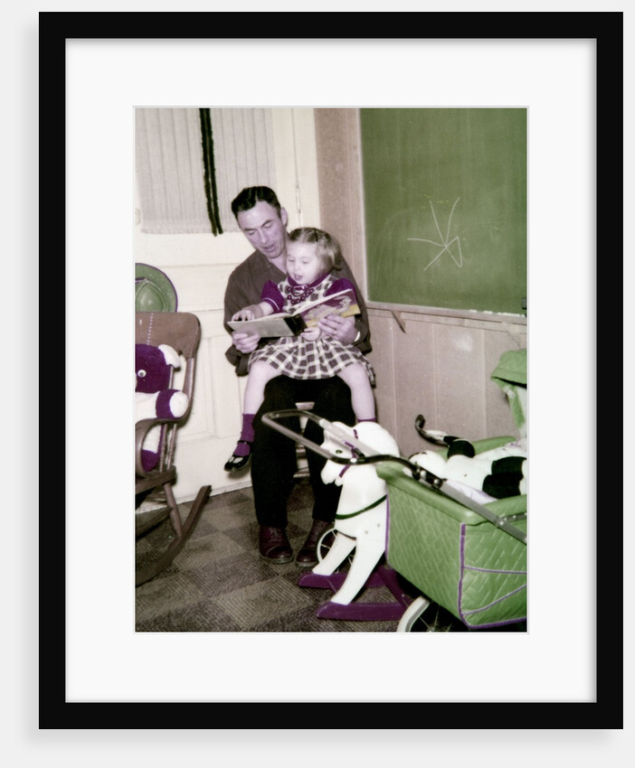 A father reads to his 4 year old daughter, ca. 1957 by Anonymous