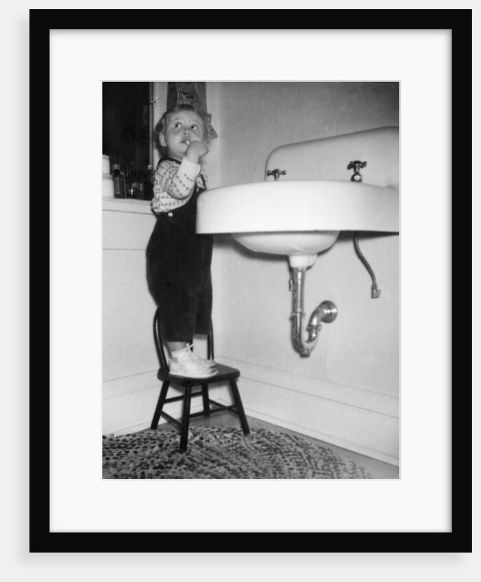 A young girl brushes her teeth at the sink, ca. 1955 by Anonymous