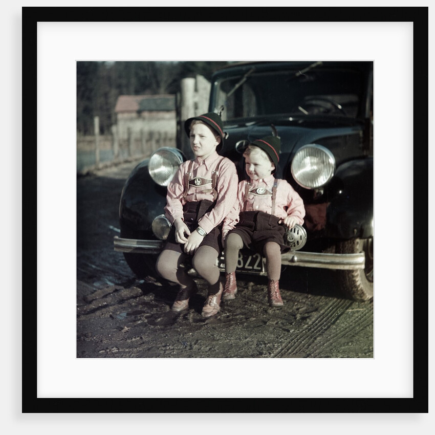Two brothers sit on the bumper of the family Mercedes Benz in Germany, ca. 1949 by Anonymous