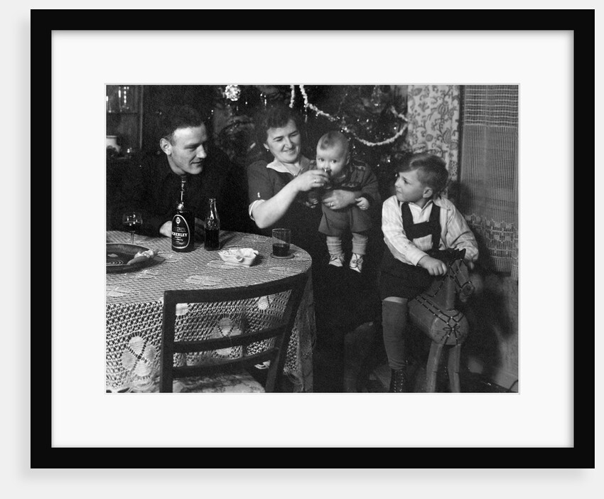One year old baby boy gets a drink of Coca Cola in front of the Christmas tree, ca. 1946 by Anonymous
