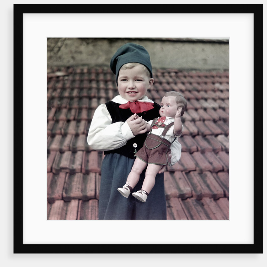 Four year old German boy stands with his lederhosen dressed doll, ca. 1949 by Anonymous