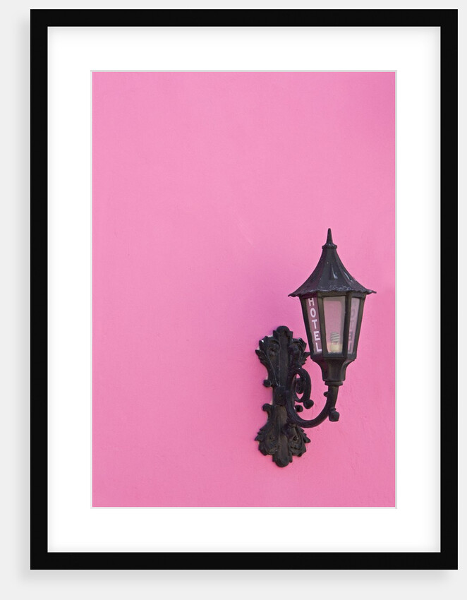 Street lamp on pink wall of Colonial style building by Anonymous