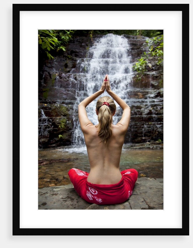 Woman meditating in front of a waterfall by Anonymous