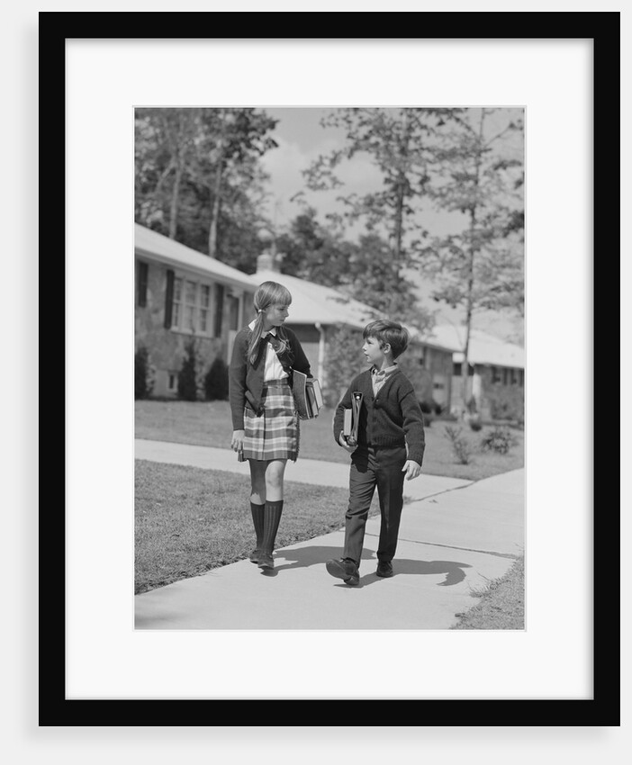 Boy girl carrying books walking to school in suburban neighborhood by Anonymous