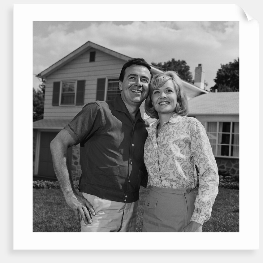 Happy couple portrait man woman smiling in front of home by Anonymous