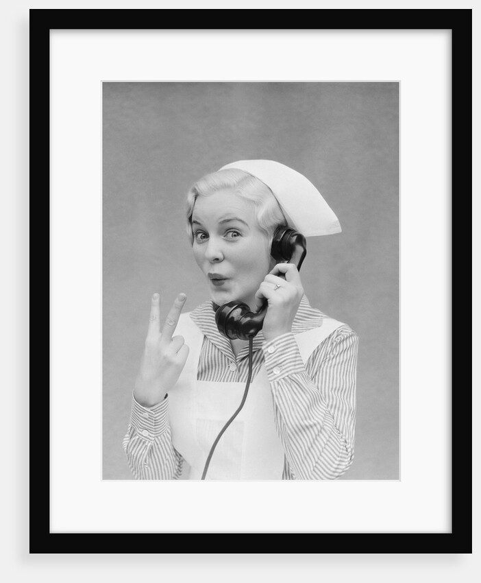 Smiling blond nurse with surprised expression talking on telephone holding up two fingers by Anonymous