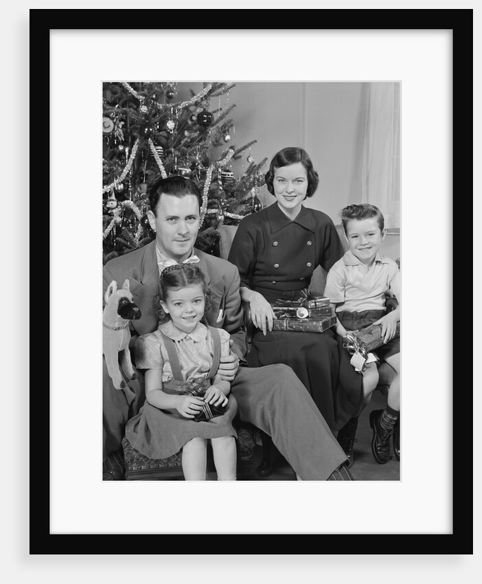 Family portrait by christmas tree by Anonymous