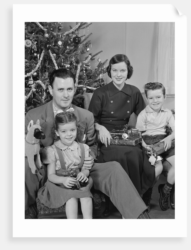 Family portrait by christmas tree by Anonymous