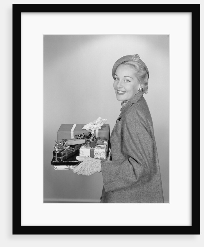 Smiling woman holding wrapped christmas presents by Anonymous