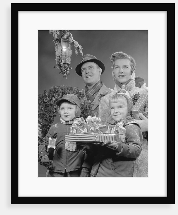 Family by lantern carrying wrapped christmas presents by Anonymous