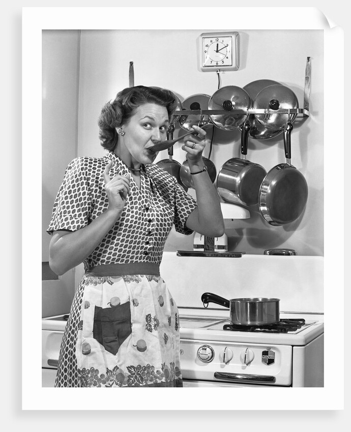 Housewife tasting with spoon by stove funny facial expression by Anonymous