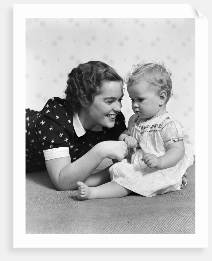 Woman mother smiling sitting playing with baby daughter by Anonymous