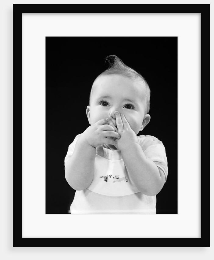 Portrait of baby covering mouth with hands fingers by Anonymous