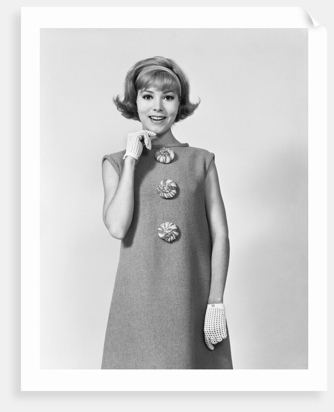 Smiling stylish young woman wearing sack dress gloves by Anonymous