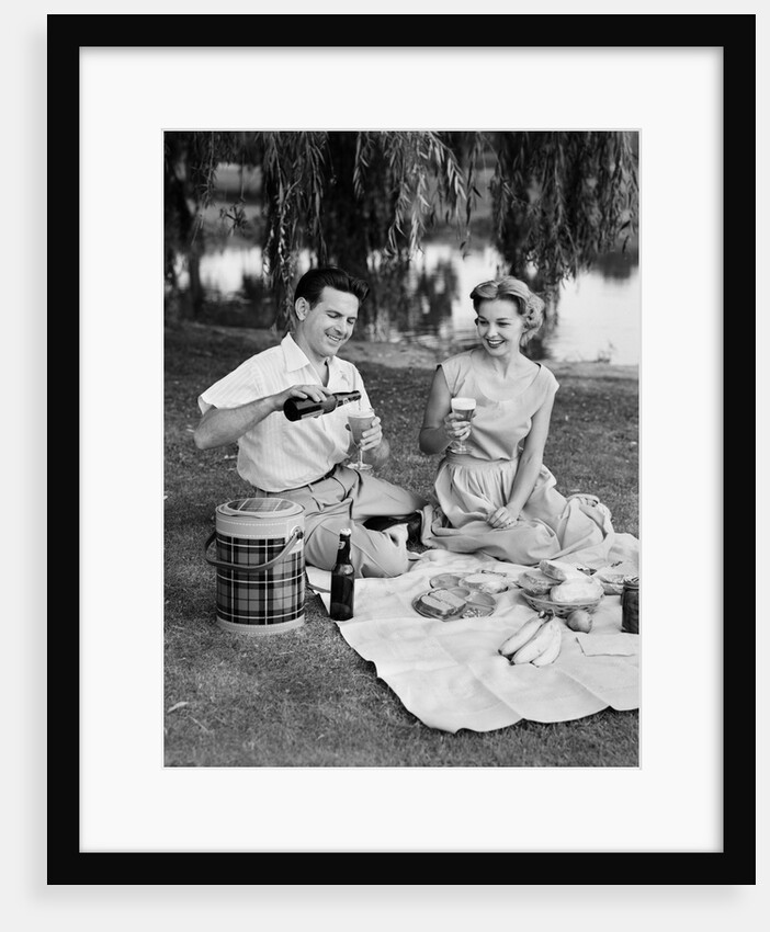 Man woman couple having a summer picnic outdoors drinking beer by Anonymous