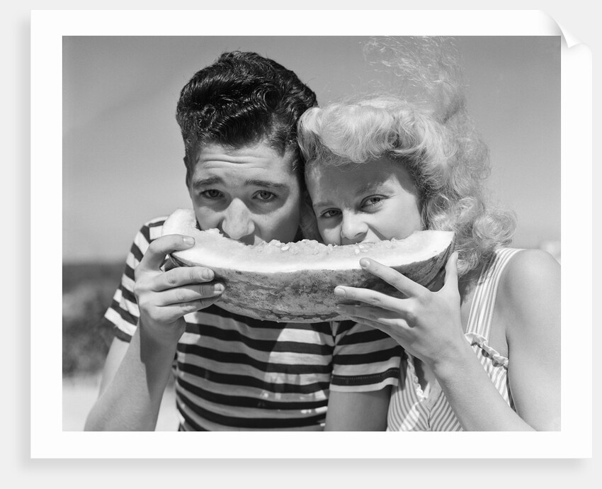 Teen age boy & girl eating slice watermelon by Anonymous
