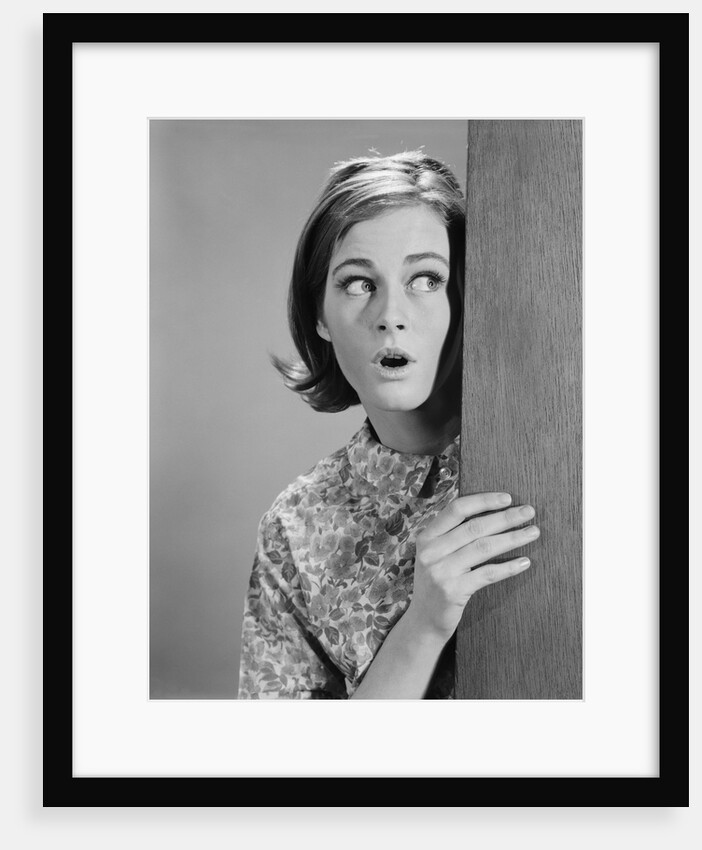 Woman peeking around door corner with fearful expression by Anonymous