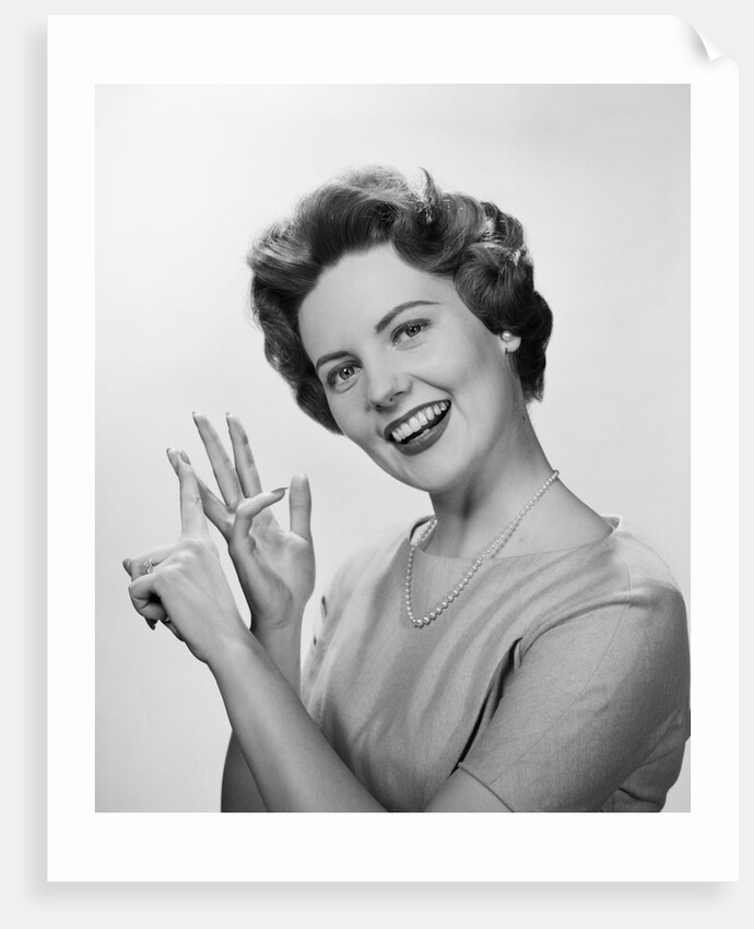 Smiling woman counting on fingers wearing pearls by Anonymous