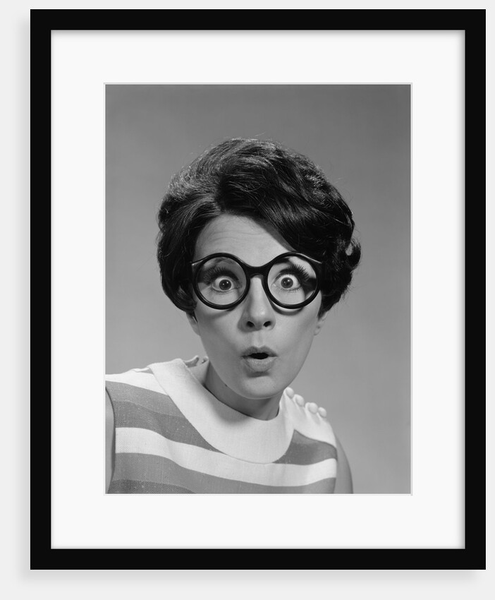 Portrait brunette wearing dark thick round eyeglasses with eyes wide open by Anonymous