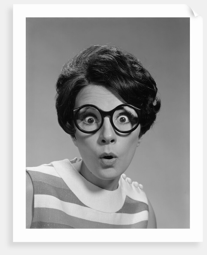 Portrait brunette wearing dark thick round eyeglasses with eyes wide open by Anonymous